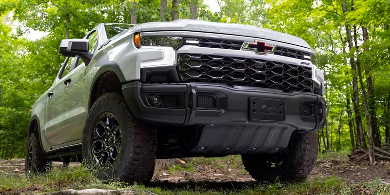 Silverado 1500 drives along the forest showcasing its front view