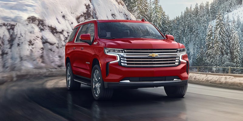A Chevrolet Suburban navigates a snowy road, embodying strength and elegance in the winter landscape