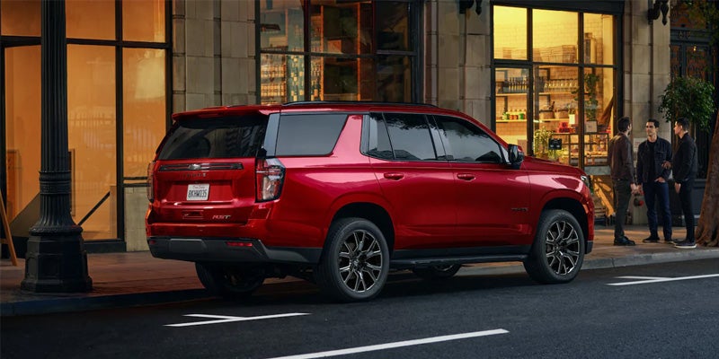 Chevy Tahoe drives along the road, showcasing its rear view with bold and rugged features.