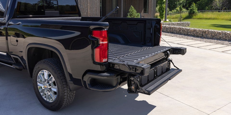 Chevrolet Silverado 2500 black in color stands parked, showcasing its rear view with bold and rugged features